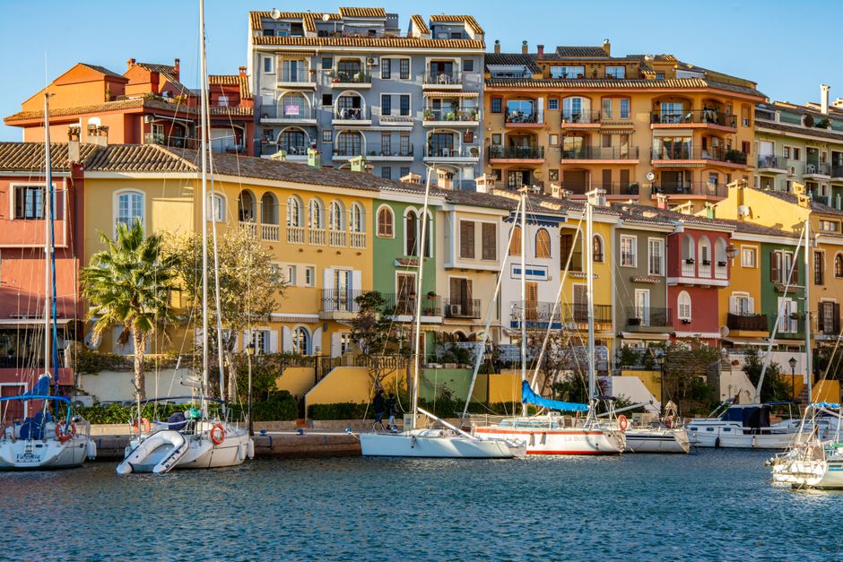Vibrante marina con edificios coloridos y botes atracados en Port Saplaya, Valencia.