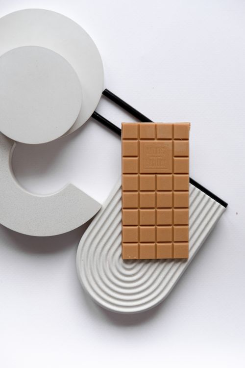 Free Stylish composition featuring a chocolate bar on a geometric background, ideal for modern design themes. Stock Photo