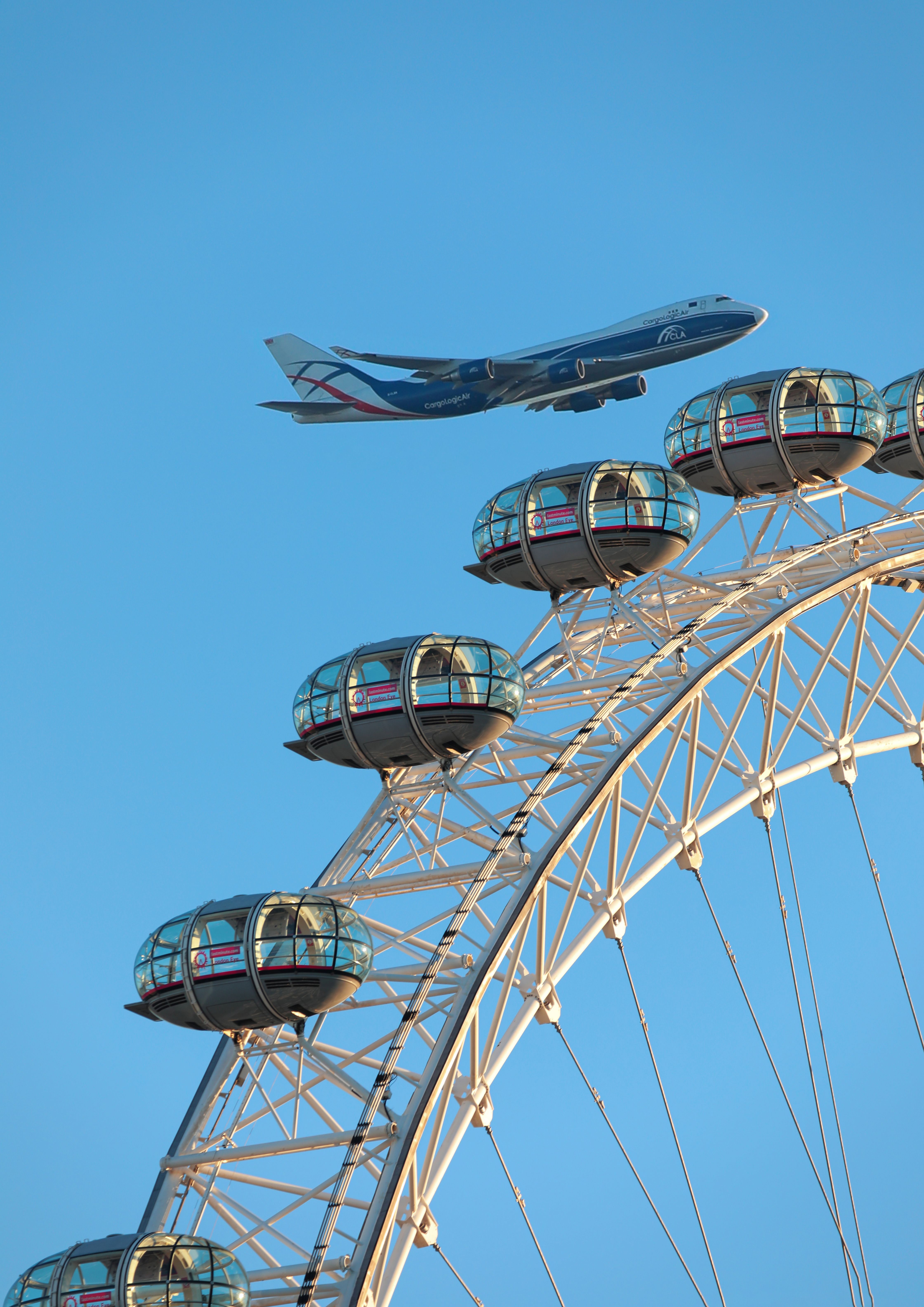 A View of a Flying Airplane and the London Eye · Free Stock Photo