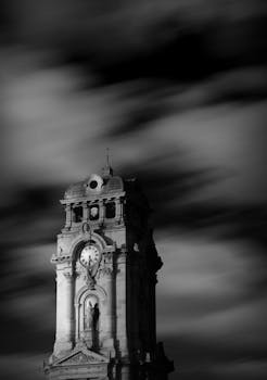 Long exposure of a historic clock tower in Pachuca, México, creating a dramatic effect.