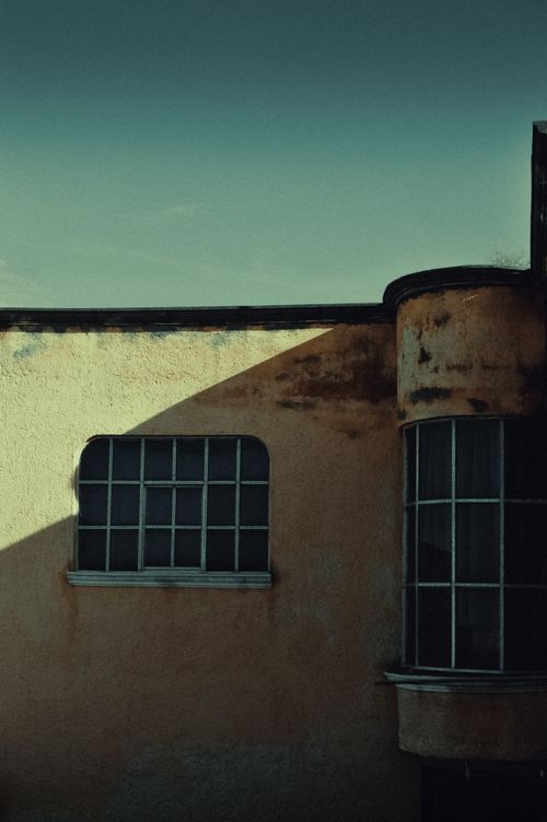 Free Abandoned building with unique Art Deco architecture casting long shadows. Stock Photo