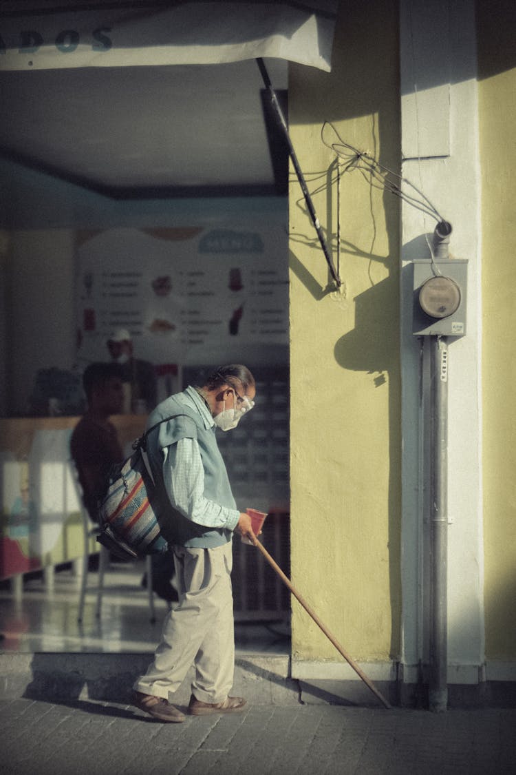 Blind Man Walking Using Cane On Sidewalk 