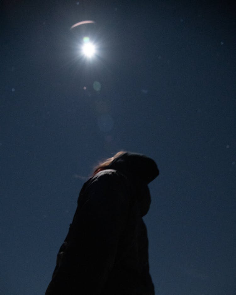 A Silhouette Of A Woman Under The Moonlight