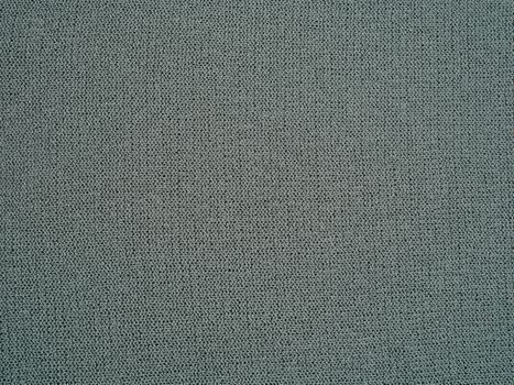 Detailed view of a gray knitted textile surface showing woven texture and fabric fibers.