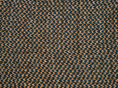 Close-up view of an intricate woven textile pattern in earthy tones.