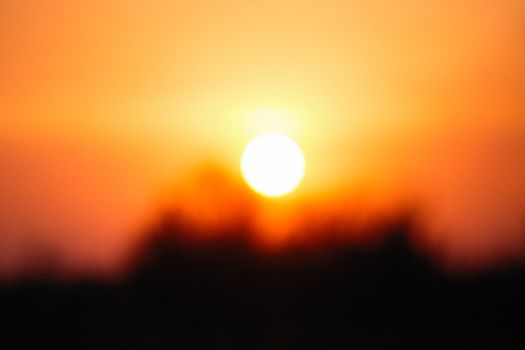 Beautiful blurred image of a sunset with vibrant orange and red hues.