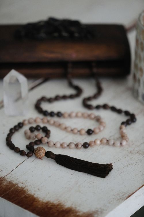 Free Close-up of elegant rosary beads with tassels on a rustic wooden surface, symbolizing spirituality. Stock Photo
