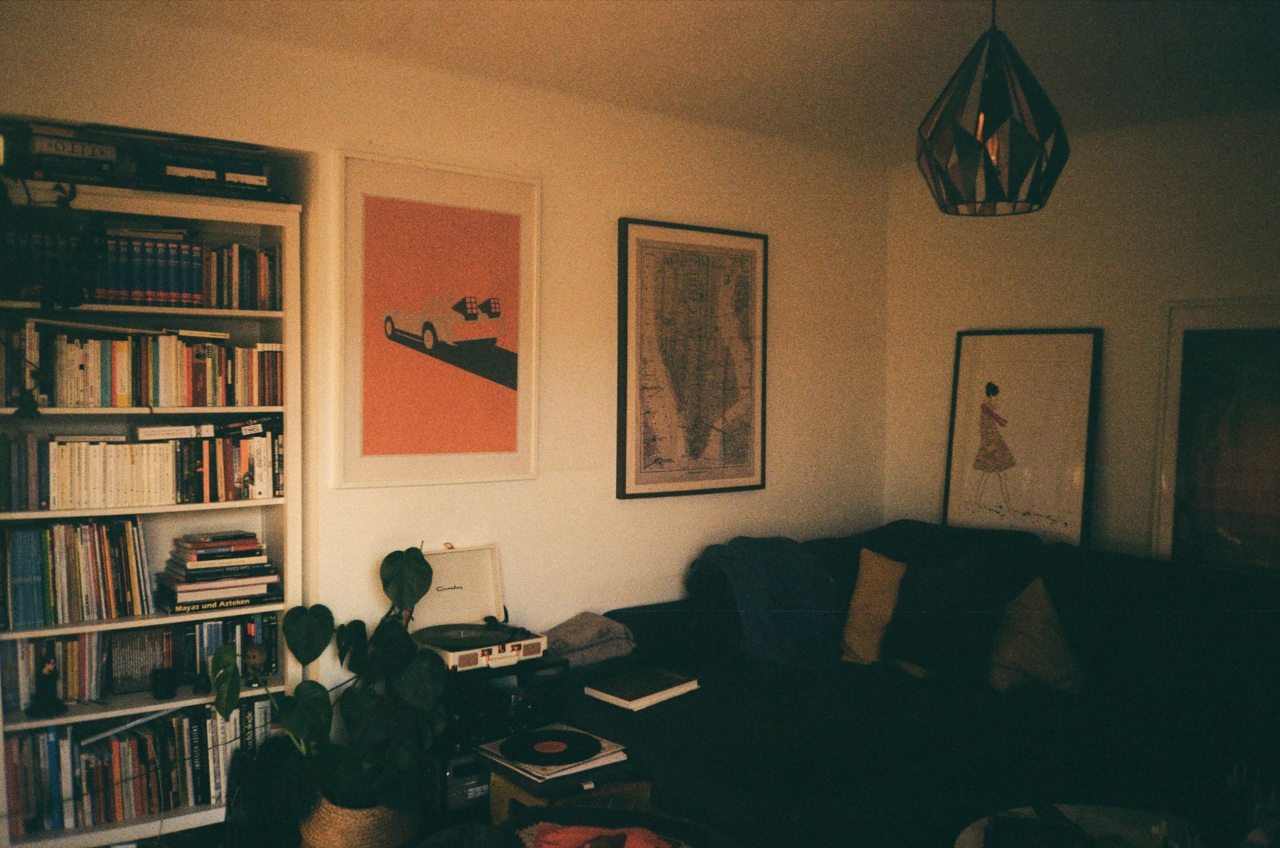 Vintage living room with phonograph, shelving, framed art and collected objects