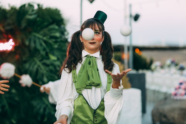 Woman In Clown Costume Juggling With Ball