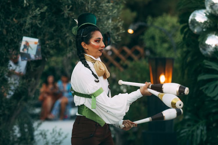 A Woman Juggling With Juggling Clubs