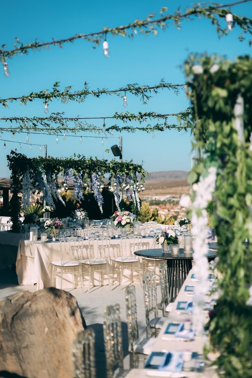 Free Beautifully decorated outdoor wedding banquet setup under lush green and floral canopy. Stock Photo
