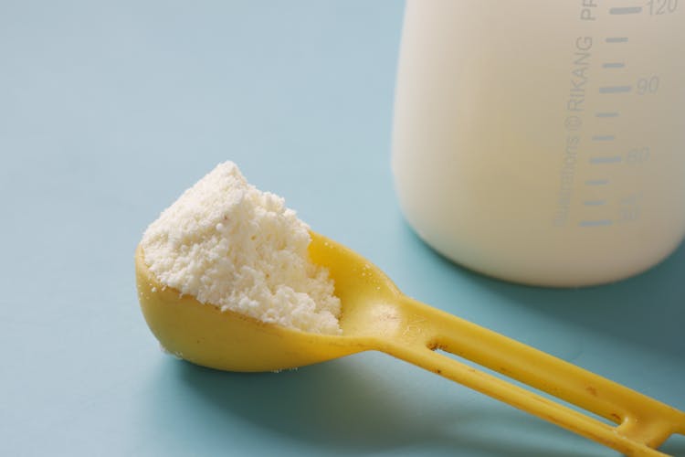 Close-up Of Plastic Spoon With Dairy Product