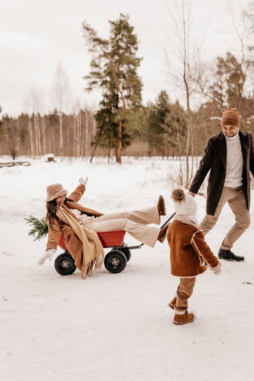 Man Pulling Woman Through Snow on Cart