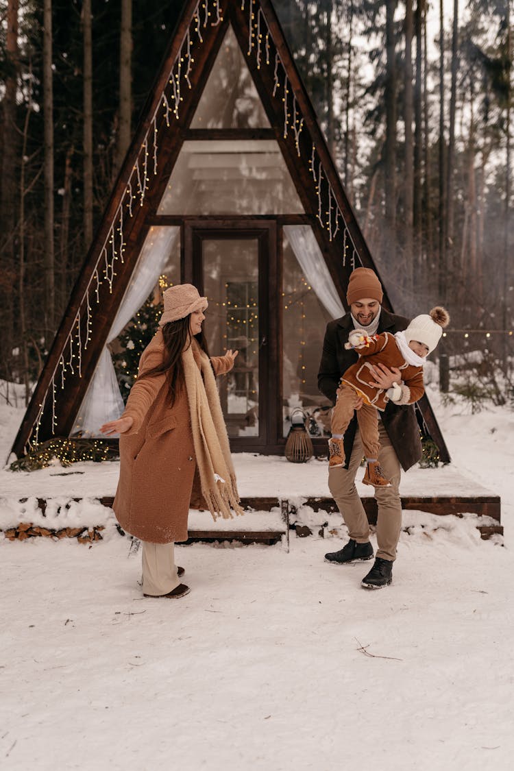 Couple Playing With Their Child In Snow