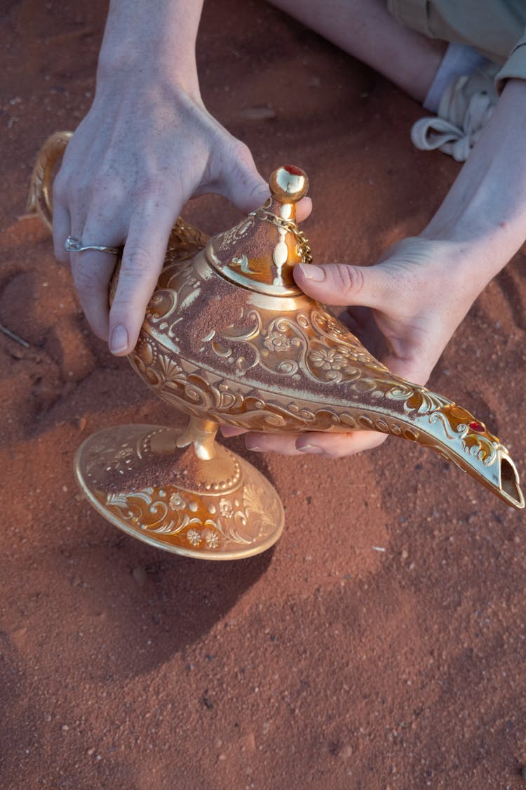 Hands Holding Intricate Oil Lamp