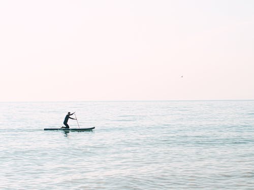 Man Riding on Paddleboard on Sea