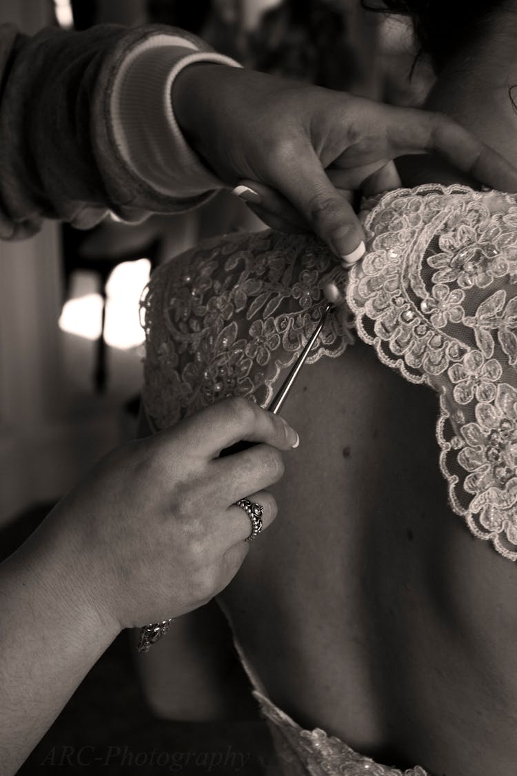 Person Sewing Beads On Floral Lace Dress