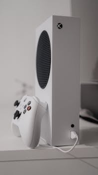 Close-up shot of a sleek white gaming console with controller, perfect for modern entertainment setups.