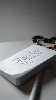 Close-up of a handwritten motivational note saying "You Got This!" on a notepad with a pen.