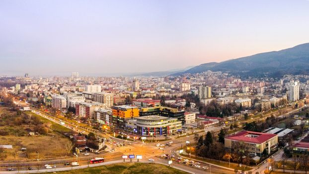 A stunning aerial view of Skopje's urban landscape at dawn, showcasing modern architecture and city life.