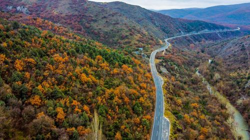 Free Captivating aerial shot of a winding road through autumn-colored hills in North Macedonia. Stock Photo