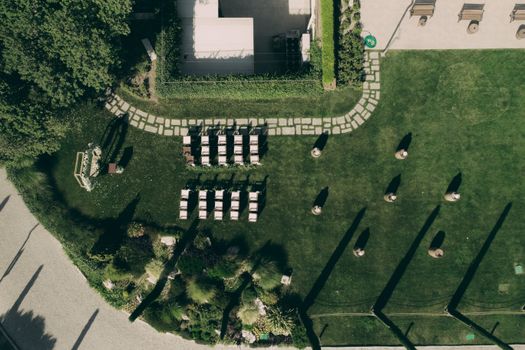 Overhead view of a beautifully arranged outdoor wedding setting with chairs on a green lawn.
