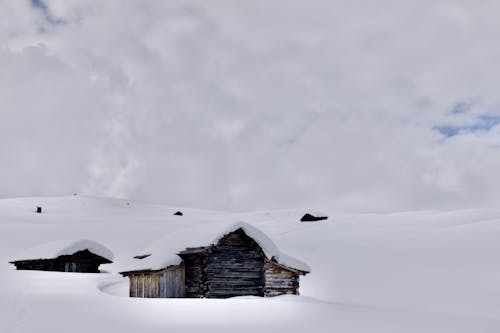 Wooden Huts on a Hillside Buried in Snow