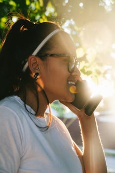 A woman talks on her cellphone while enjoying the sunlight outdoors in a casual setting.