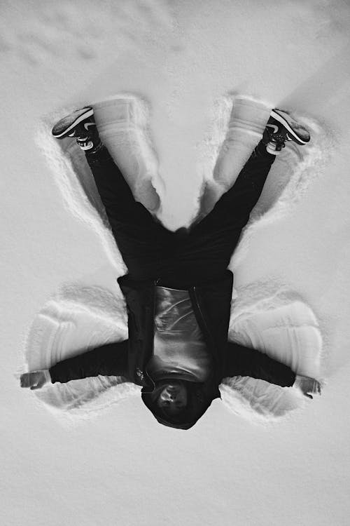 Free Grayscale Photo of a Man Lying on Snow Stock Photo