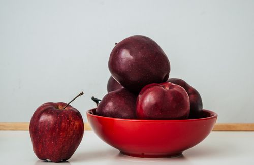 Free Close-up of fresh red apples in a bowl on a white surface, highlighting healthy eating. Stock Photo
