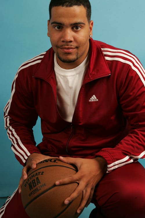 Man in Red Zip Up Jacket Holding Basketball