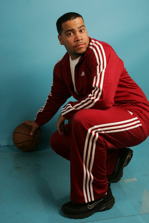 Man Wearing a Red Tracksuit Holding a Basketball