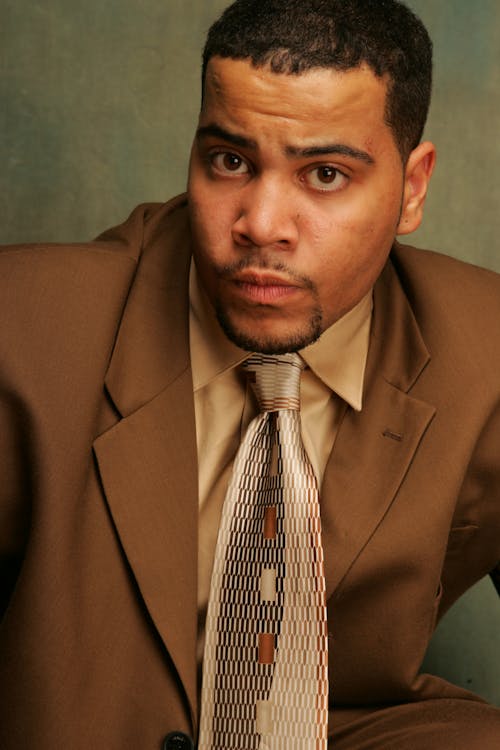 Close Up Photo of a Man in Brown Suit