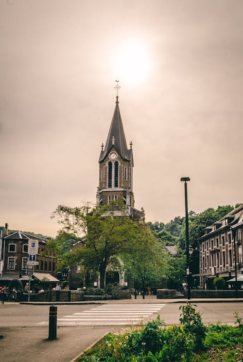 Brown and Green Church Near Tree Under White Skies