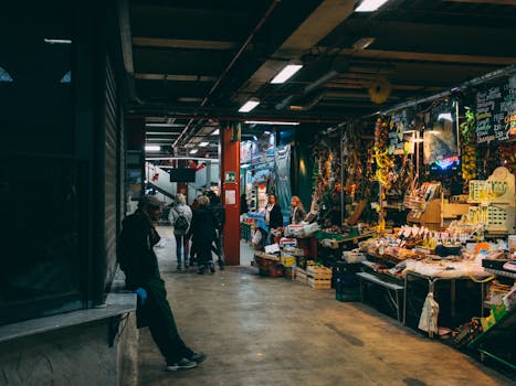 Bustling indoor market scene in Florence, Italy, showcasing local goods and people shopping.