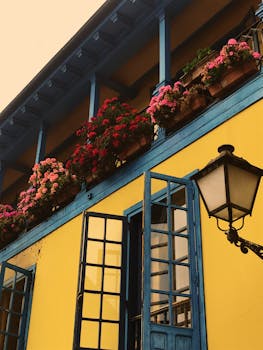 Vibrant blue and yellow building facade in Madrid showcasing colorful flowers and traditional architecture.