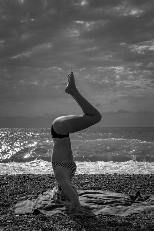 Free A Woman Doing a Headstand at the Beach  Stock Photo