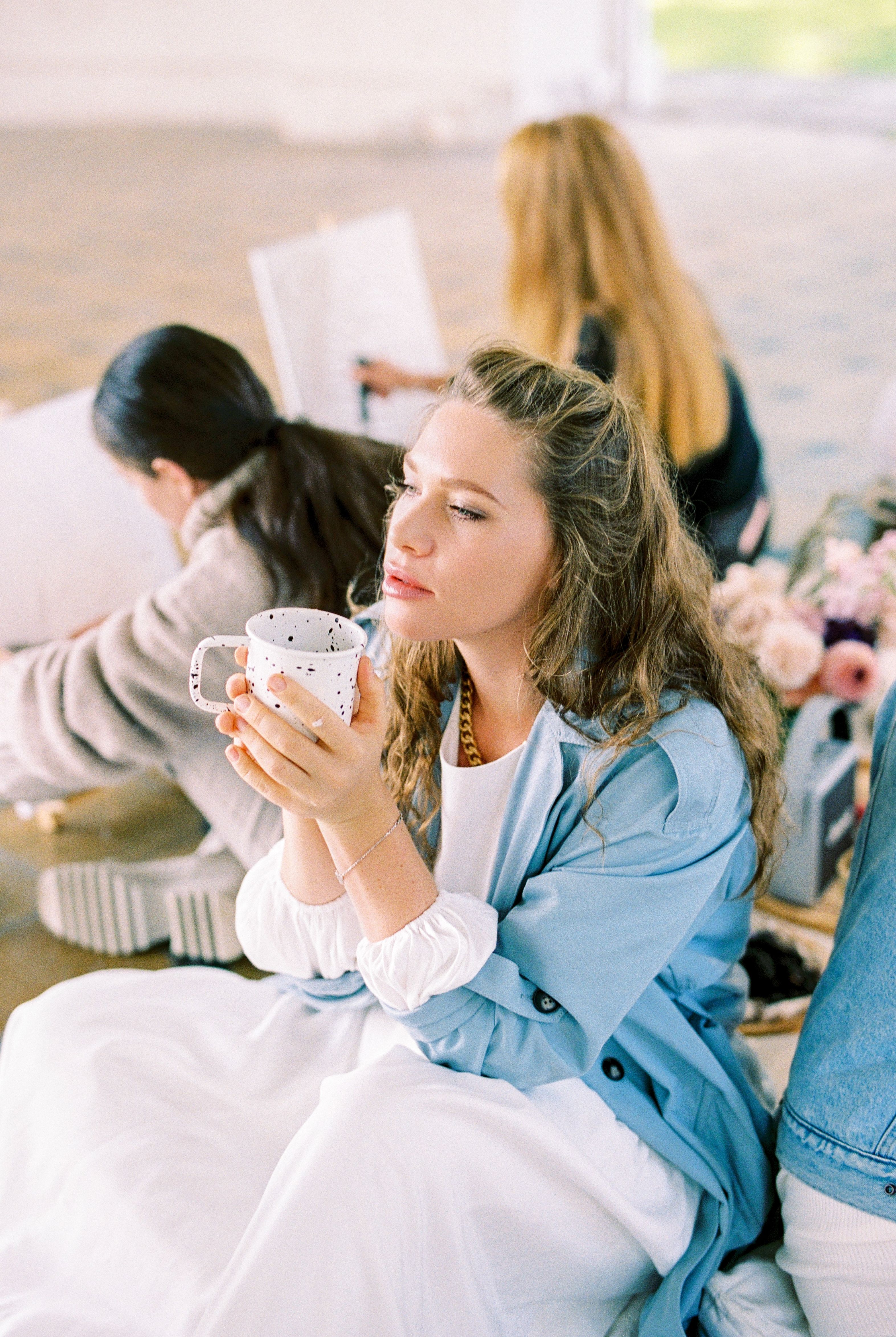 A Woman in Blue Coat Holding a Mug while Looking Afar · Free Stock Photo