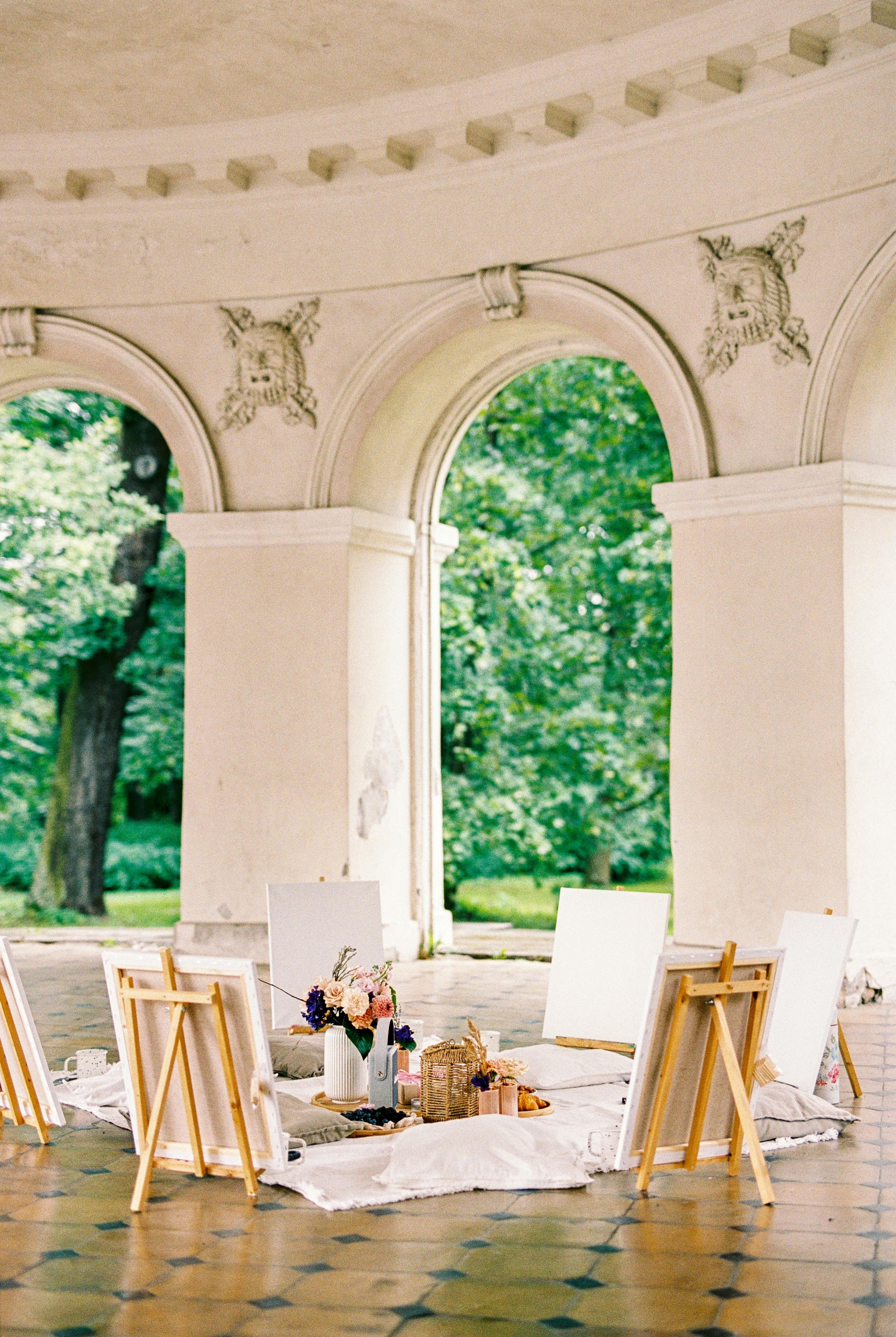 A serene art workshop setup in a classical pavilion with easels and canvas.