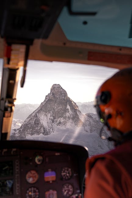 Stunning aerial view of the Matterhorn from a helicopter cockpit, showcasing snow-covered peaks.