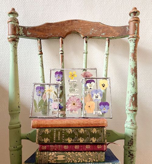 Free Rustic wooden chair displays pressed flowers with vintage books stacked below. Stock Photo