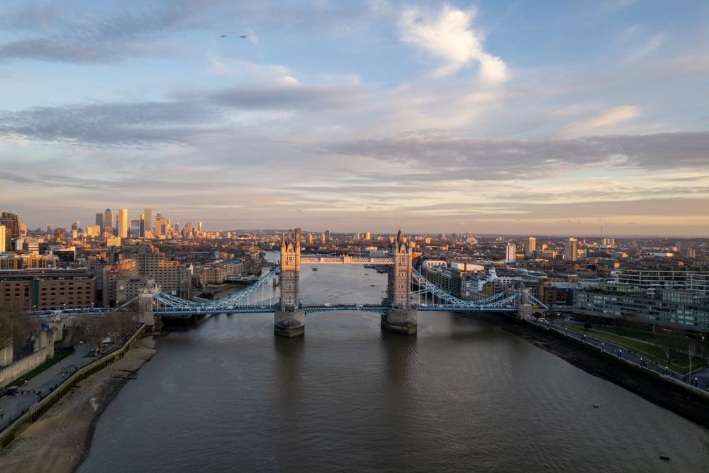 A breathtaking aerial shot of London's Tower Bridge with the city skyline at dusk.