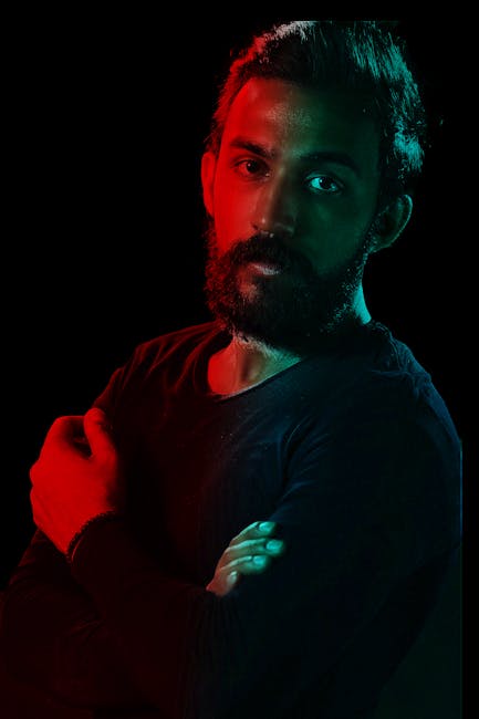 Artistic studio portrait of a handsome bearded man with dramatic lighting.