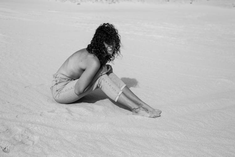 Topless Woman Sitting On Sand