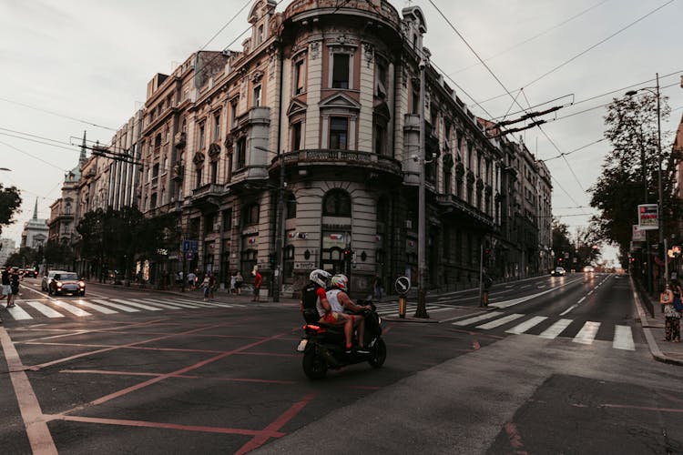 People Riding A Motorcycle On Road