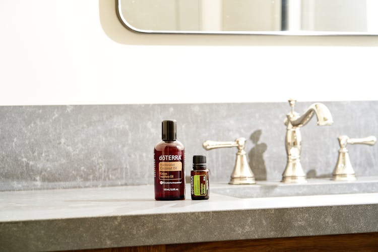 Brown Bottles Of Essential Oils On A Bathroom Counter Top