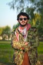 Man in Green and Brown Camouflage Jacket Wearing Black Sunglasses