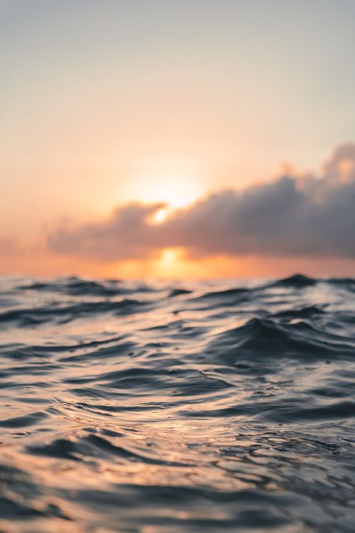 Free Golden sunrise over calm ocean waves at Balneário Camboriú, Brazil, creating a serene seascape. Stock Photo