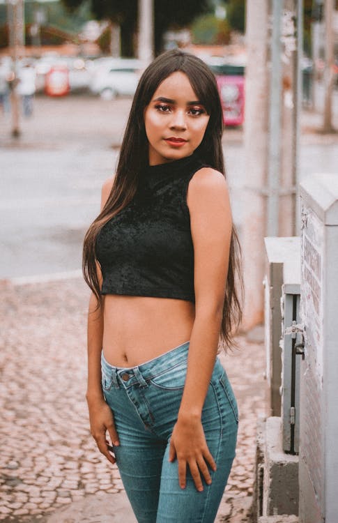 Young woman wearing black tank top and blue jeans stock photo