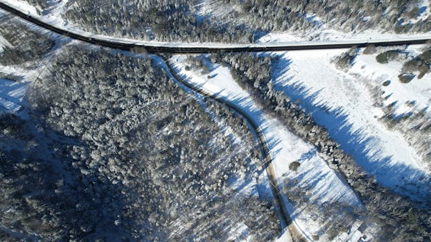 Aerial view of a snow-covered forest and roads in Huntsville, Ontario, Canada during winter.